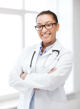 healthcare and medical concept - smiling african female doctor in hospital