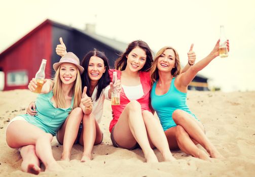 summer holidays and vacation - girls with drinks showing thumbs up on the beach