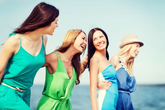 summer holidays and vacation - girls walking on the beach