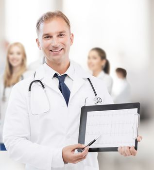 healthcare and medical concept - male doctor with stethoscope showing cardiogram