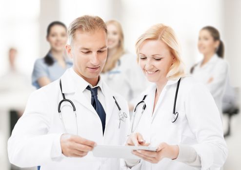 healthcare and technology concept - two doctors looking at tablet pc