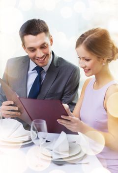 restaurant, couple and holiday concept - smiling couple with menu at restaurant