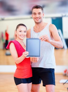 fitness, sport, training, gym and lifestyle concept - two smiling people showing blank tablet pc screen