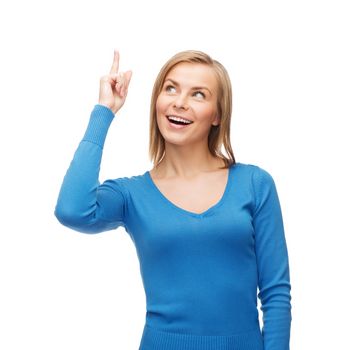 advertisement concept - attractive young woman in casual clothes pointing her finger up