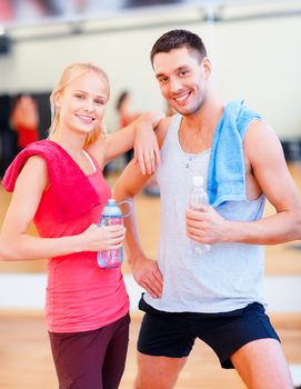 fitness, sport, training, gym and lifestyle concept - two smiling people in the gym