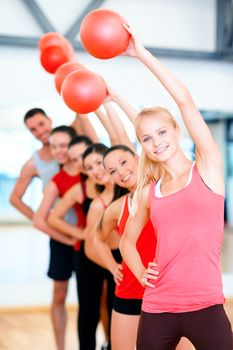 fitness, sport, training, gym and lifestyle concept - group of smiling people working out with stability balls in the gym