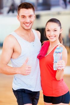 fitness, sport, training, gym and lifestyle concept - two smiling people in the gym