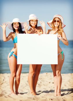 summer holidays and vacation - girls in bikinis holding blank white board on the beach