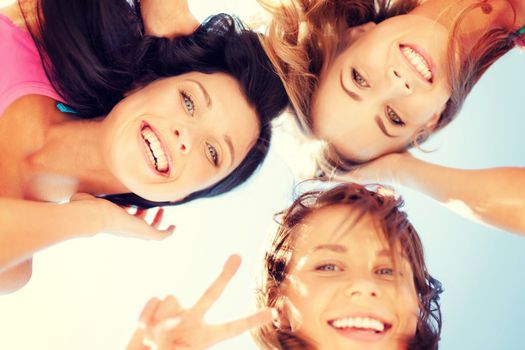 summer holidays and vacation - girls faces with shades looking down