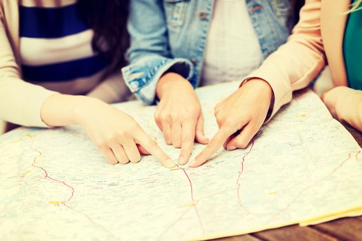 holidays and tourism concept - women with tourist map in the city