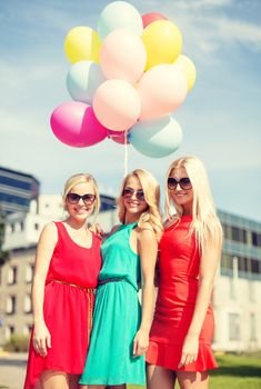 holidays and tourism, friends, hen party, blonde girls concept - three beautiful women with colorful balloons in the city