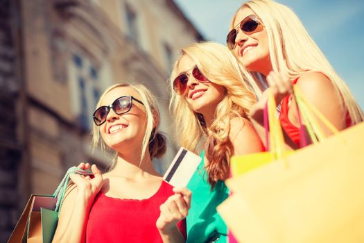 sale and tourism, happy people concept - beautiful blonde women with shopping bags in the ctiy