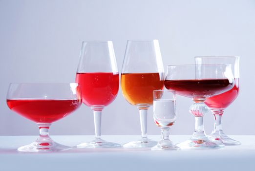 Alcohol conceptual image. Glasses full of wine and whisky on isolated background.