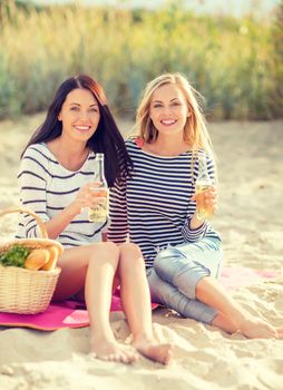 summer holidays and vacation concept - girls with drinks on the beach