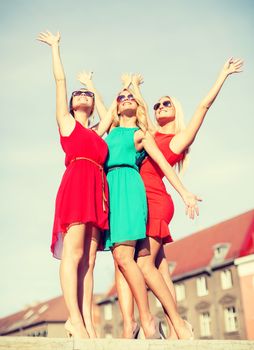 holidays and tourism, friends, hen party, blonde girls concept - three beautiful women in the city waving hands