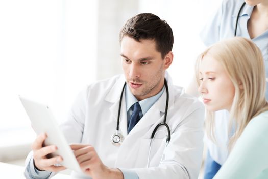 healthcare, medical and technology - doctor showing something patient on tablet pc in hospital