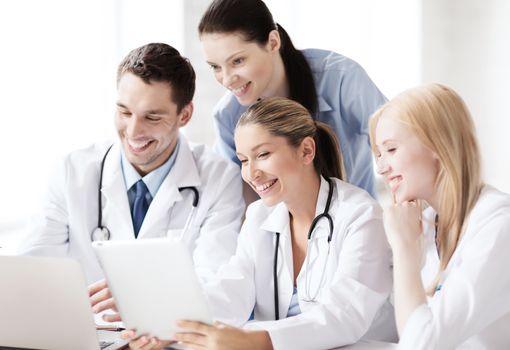 healthcare, medical and technology concept - group of doctors looking at tablet pc