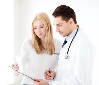 healthcare and medical concept - two doctors writing prescription