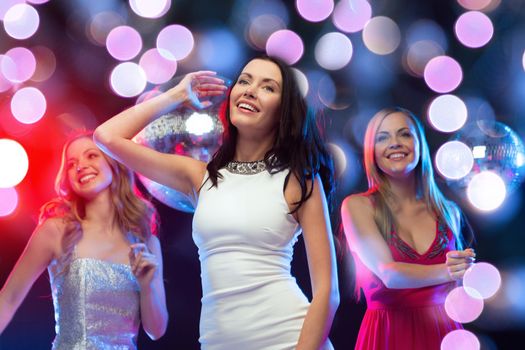 new year, celebration, friends, bachelorette party, birthday concept - three beautiful women in evening dresses dancing in the club