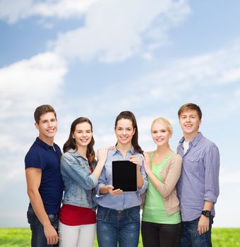 education and modern technology concept - smiling students showing blank tablet pc computer screen