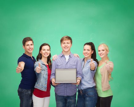 education, advertisement and new technology concept - smiling students with laptop computer blank screen showing thumbs up