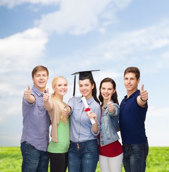 education and people concept - group of standing smiling students with diploma and corner-cap showing thumbs up