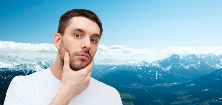 health and beauty concept - beautiful calm man touching his face