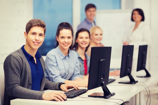 education, technology and internet concept - students looking at computer monitor at school