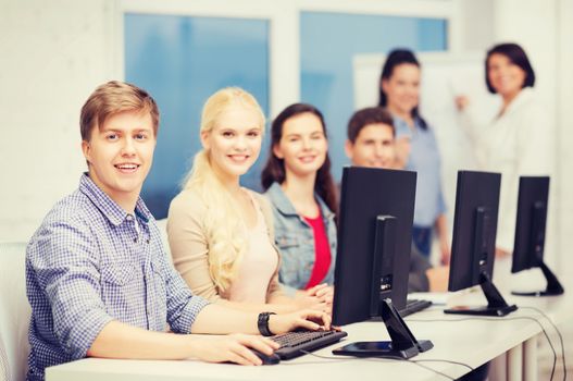 education, technology and internet concept - students looking at computer monitor at school