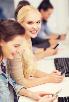 education, technology and internet concept - students with smartphones