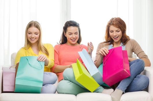 shopping and lifestyle concept - three smiling teenage girls with many shopping bags at home