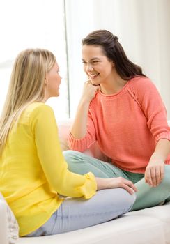 friendship and happiness concept - two girlfriends having a talk at home