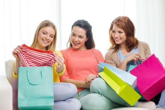 shopping and lifestyle concept - three smiling teenage girls with many shopping bags at home