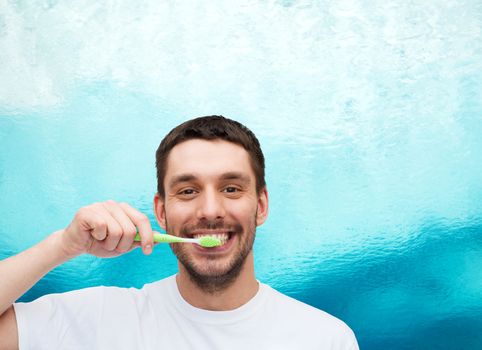 health and beauty concept - smiling young man with toothbrush
