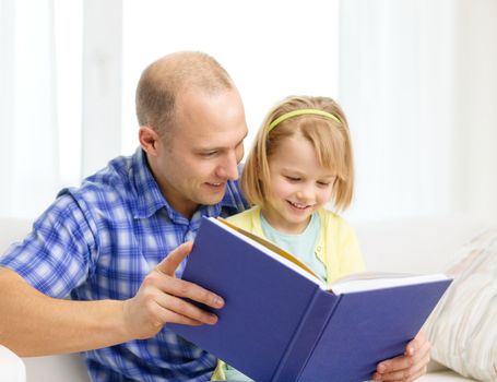 family, children, education, school and happy people concept - smiling father and daughter with book at home