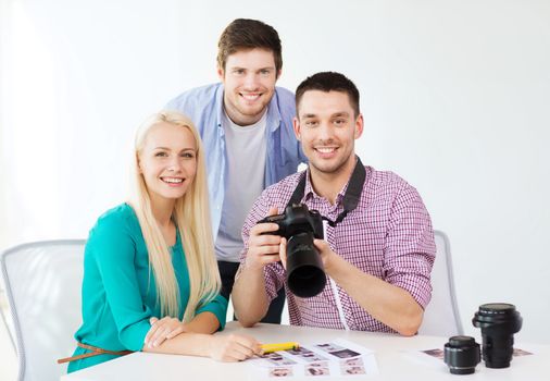 business, education, office and startup concept - smiling creative team with photocamera working in office