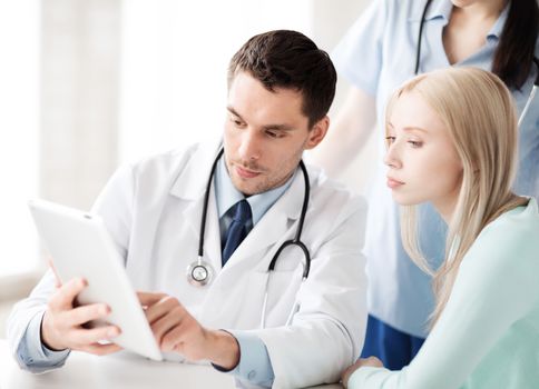 healthcare, medical and technology - doctor showing something patient on tablet pc in hospital