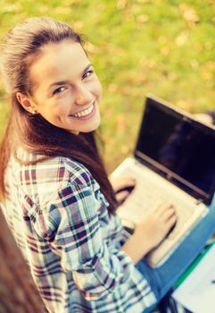 education, technology and internet concept - smiling teenager with laptop computer