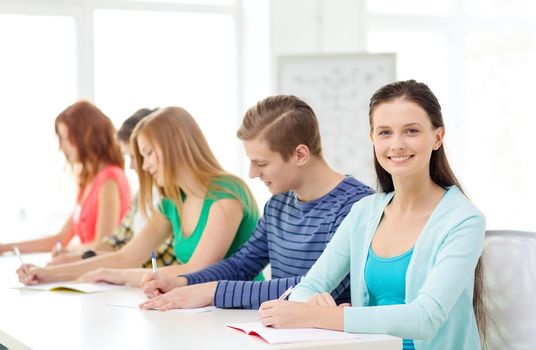 education and school concept - five smiling students with textbooks at school