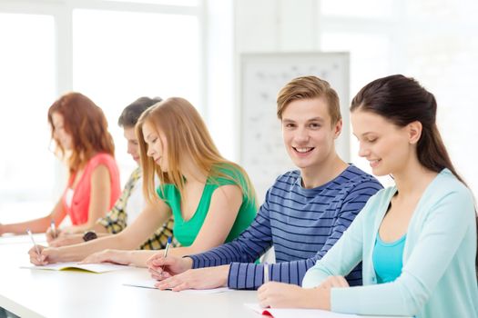 education and school concept - five smiling students with textbooks at school