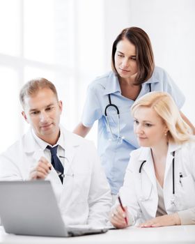 healthcare, medical and technology - group of doctors looking at laptop on meeting