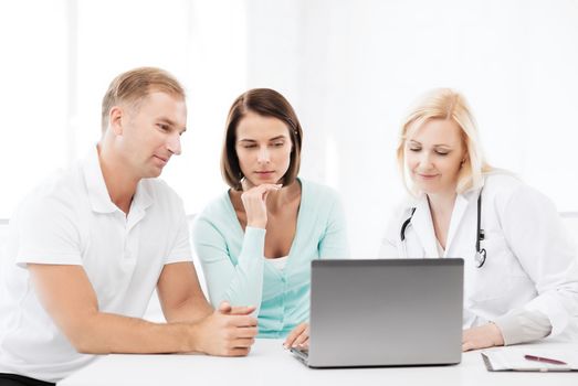 healthcare, medical and technology concept - doctor with patients looking at laptop