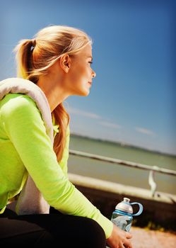 sport, fitness, exercise and lifestyle concept - woman resting after doing sports outdoors
