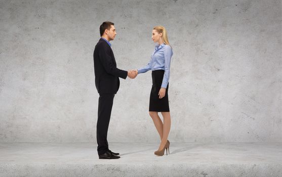 business and office concept - businessman and businesswoman shaking hands