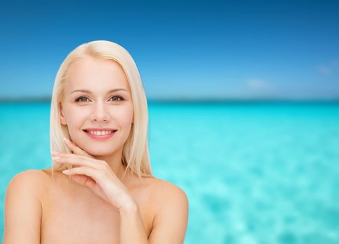 health and beauty concept - face and hands of beautiful woman