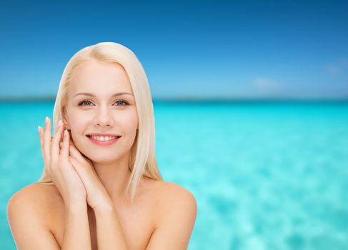 health and beauty concept - face and hands of happy woman