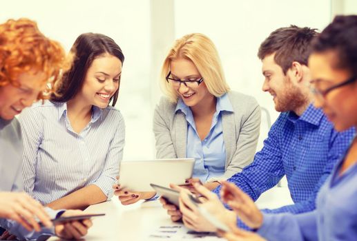 business, office and startup concept - smiling creative team with table pc computers and papers working in office