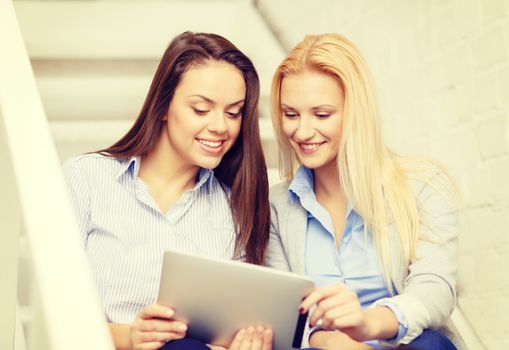 business, technology and startup concept - smiling creative team with tablet pc computer sitting on staircase