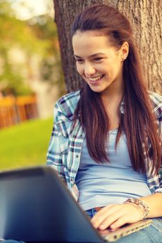 education, technology and internet concept - smiling teenager with laptop computer