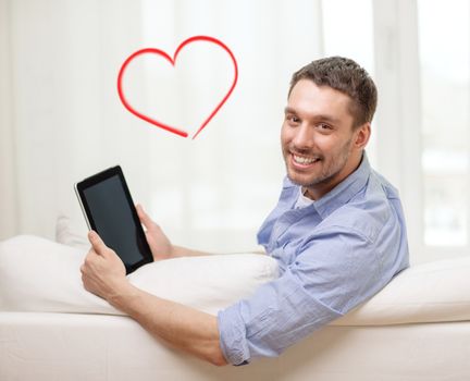 technology, home and lifestyle concept - smiling man working with tablet pc computer at home